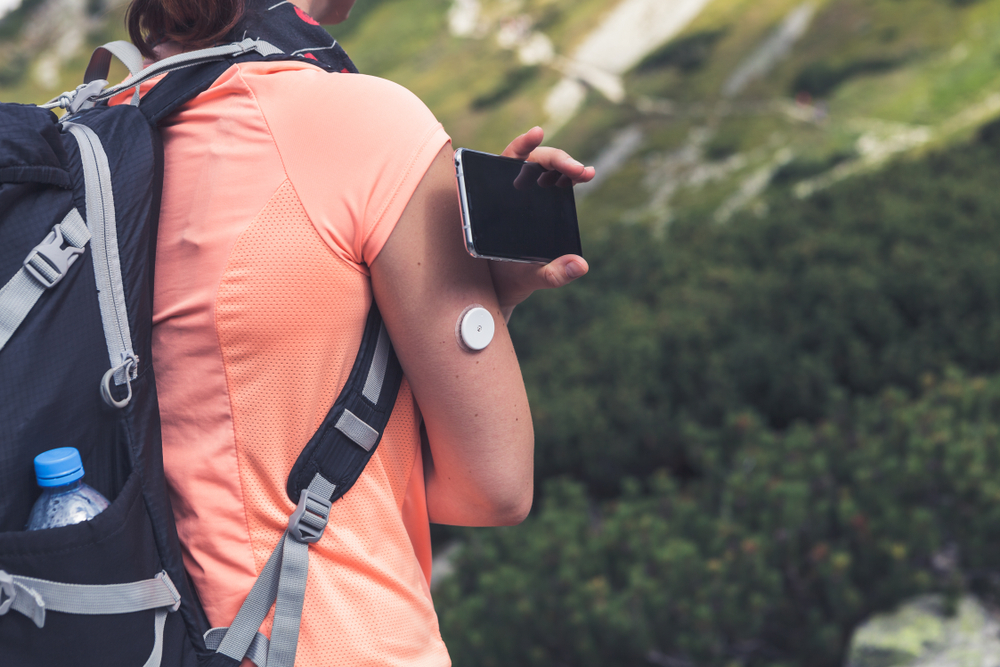 Young woman checking blood sugar with digital monitor.