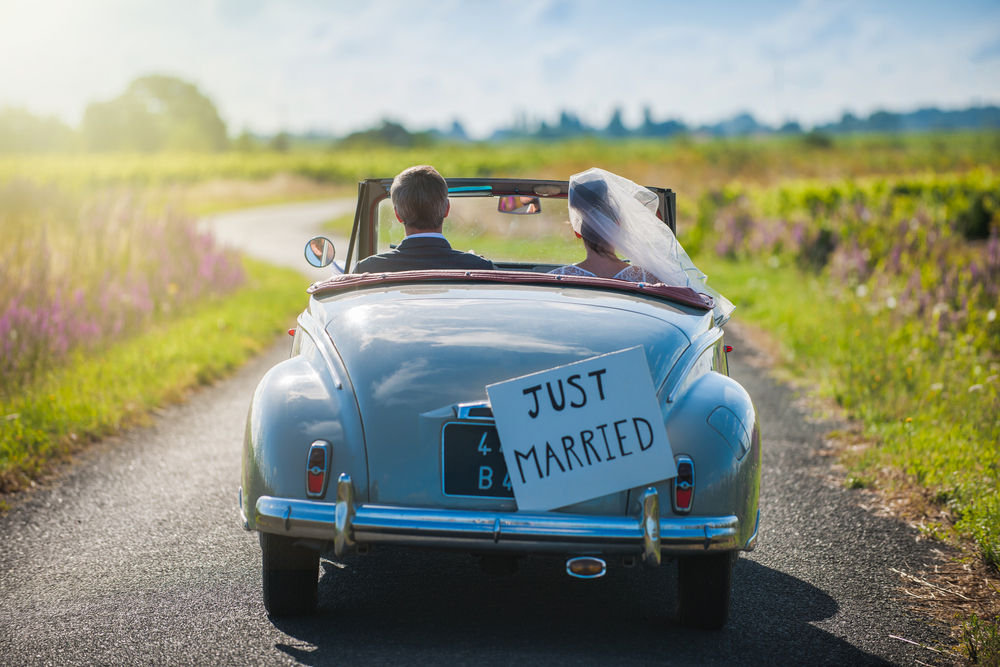 Newlywed couple driving away.