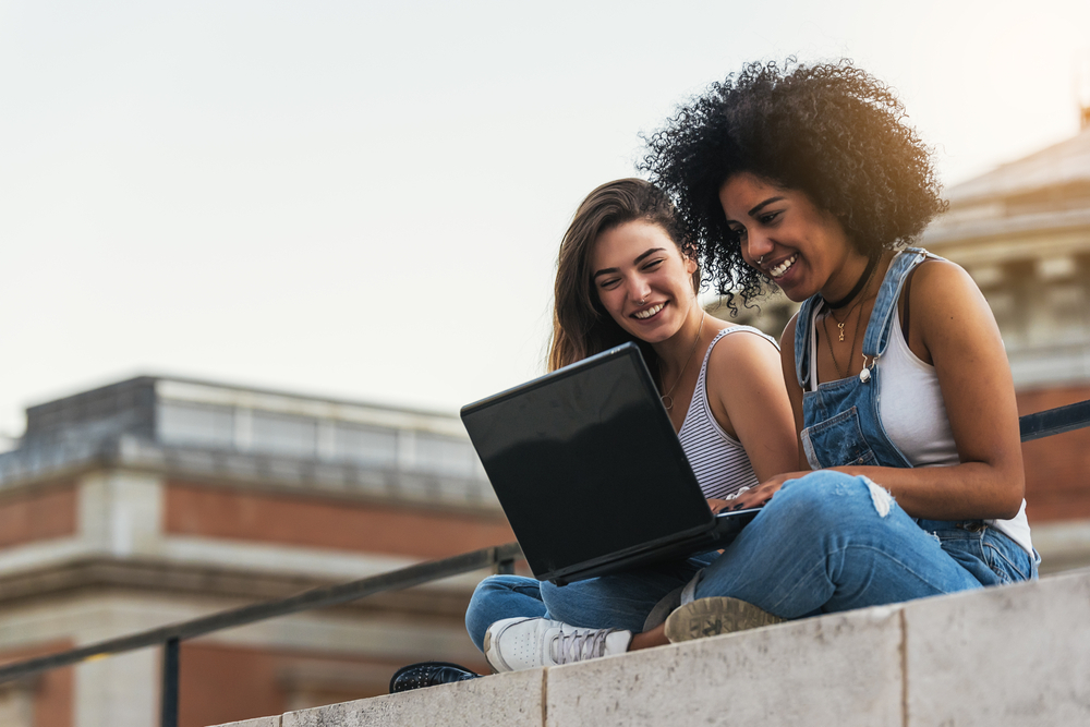 Two young women sitting outside