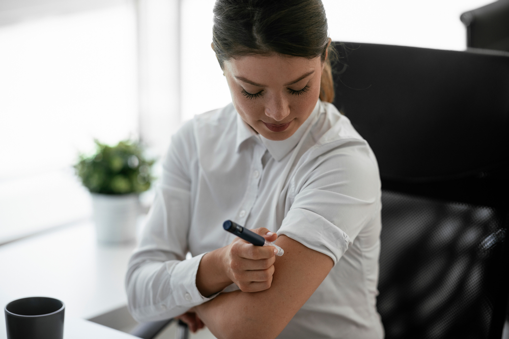 A woman uses an insulin pen