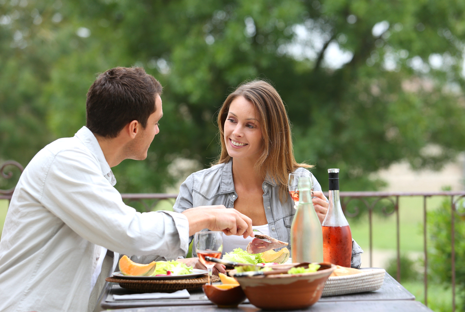 Happy couple enjoying a meal outdoors.