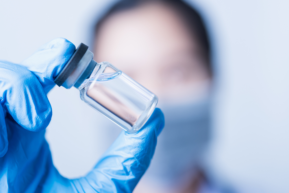 A doctor holding up a vial.