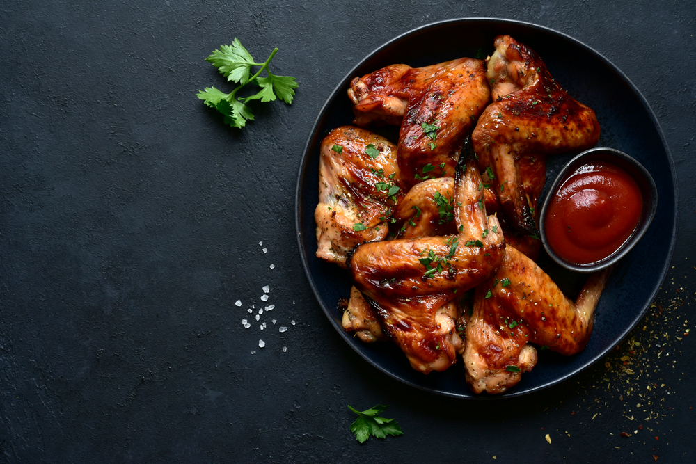 Grilled chicken wings with ketchup.