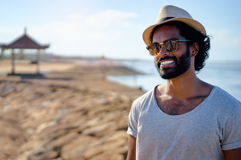 Young man with type 1 diabetes smiling on beach