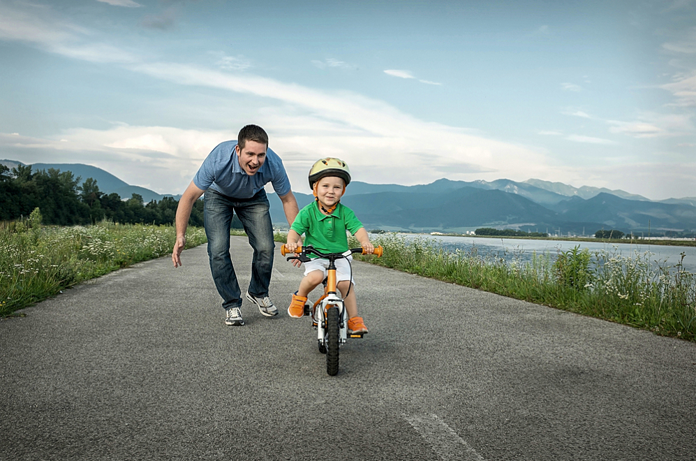 Father watches his son with diabetes ride a bike on his own