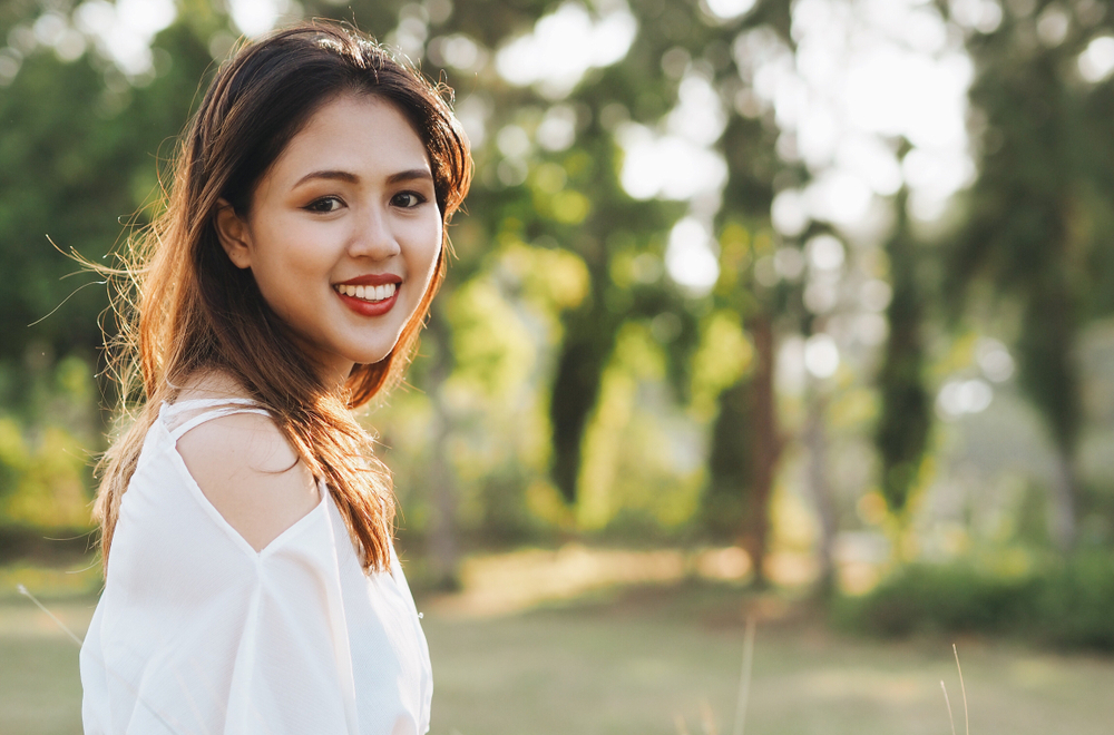 Young woman with diabetes smiles while standing outside in the sunshine