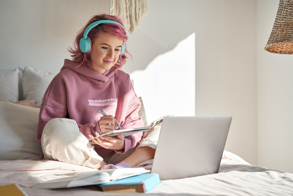 A teenage girl living with t1d writes in a notebook.