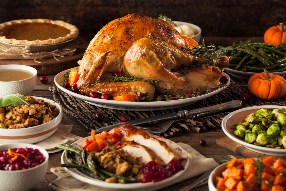 A roasted turkey with Thanksgiving-themed side dishes.