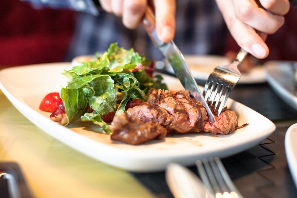 A person cutting steak.