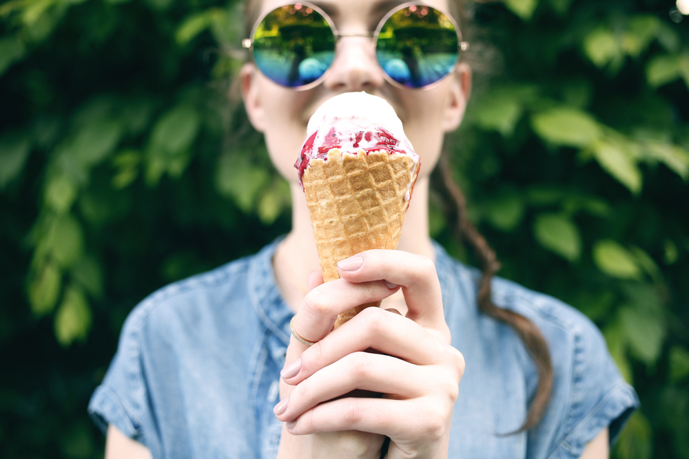 A woman eats an ice cream cone.