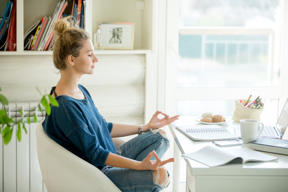 A woman meditating in her office