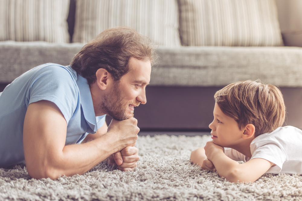 A father and son lying on the floor