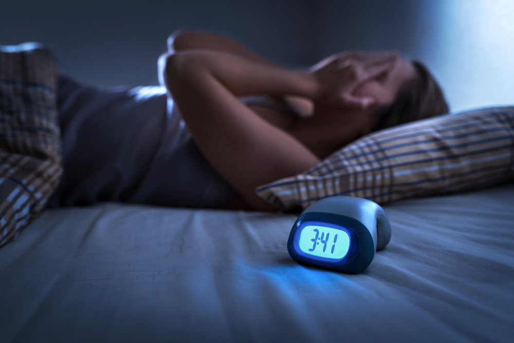 A woman experiencing restless sleep in the early morning hours.