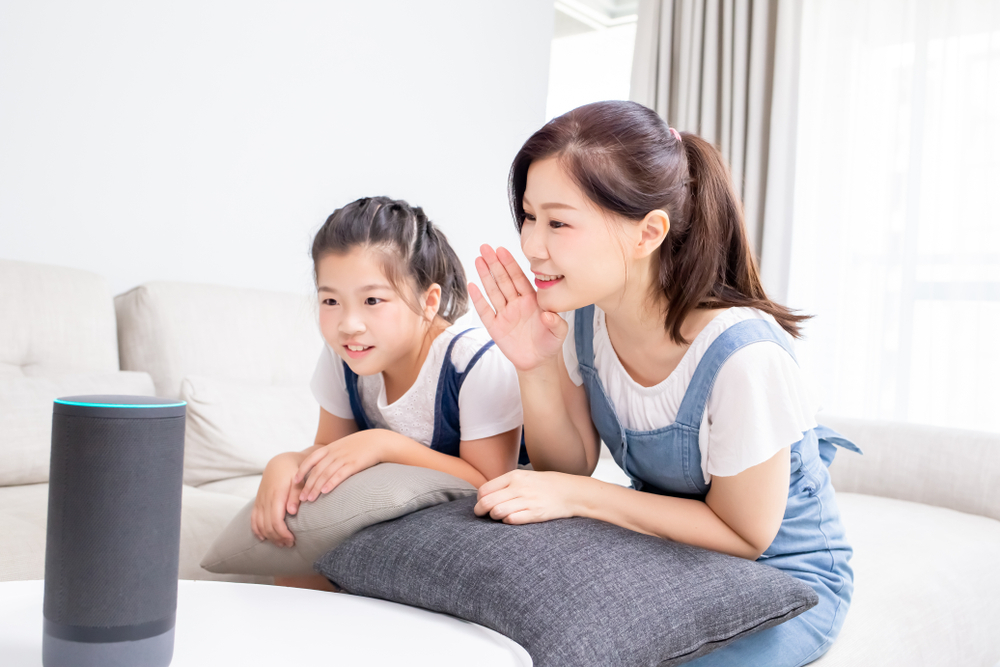 Mother and daughter using smart speaker