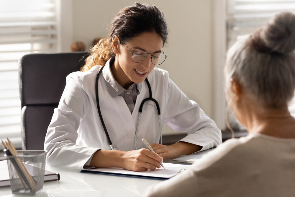 A doctor writes a prescription for a patient