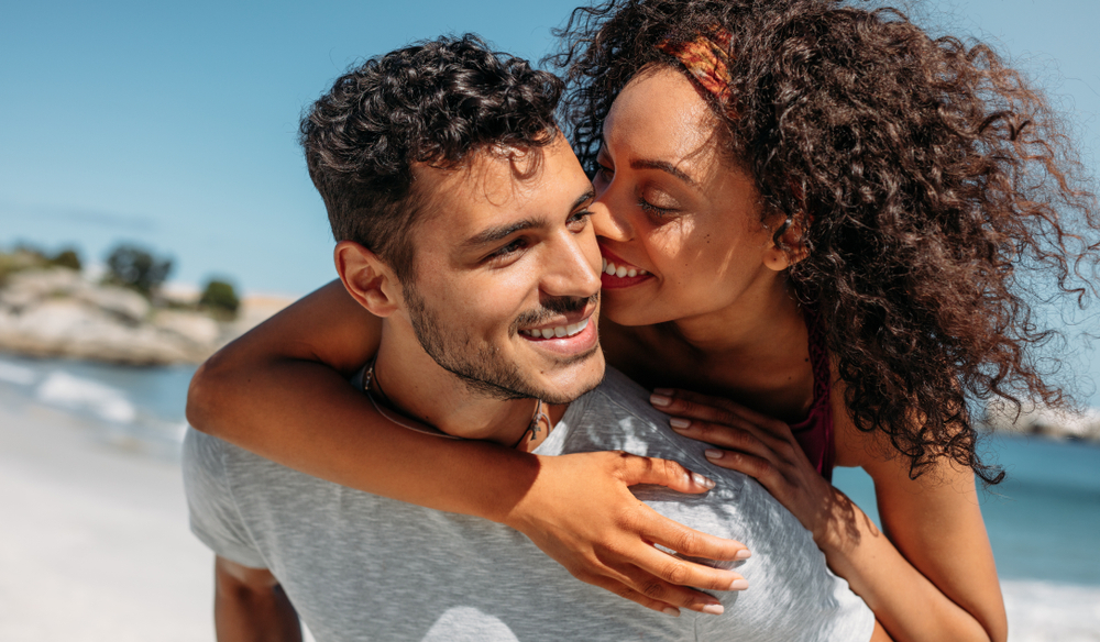 Young man with type 1 diabetes enjoys a sunny day on the beach with his girlfriend.