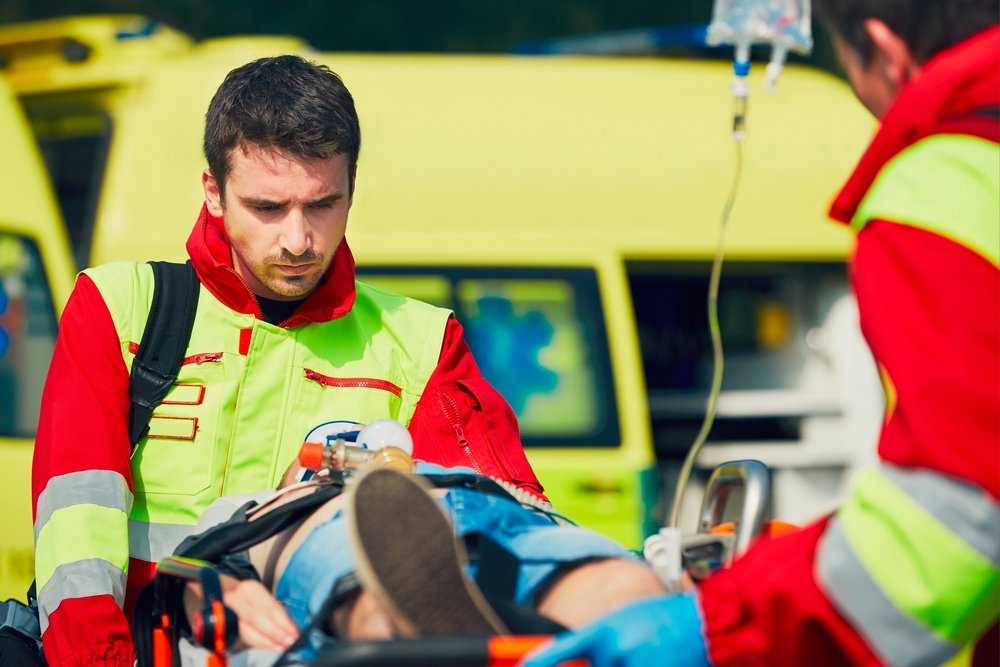 Emergency medical technicians in front of an ambulance.