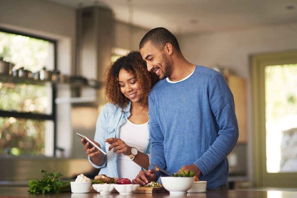 A young couple looks at a recipe on a cell phone