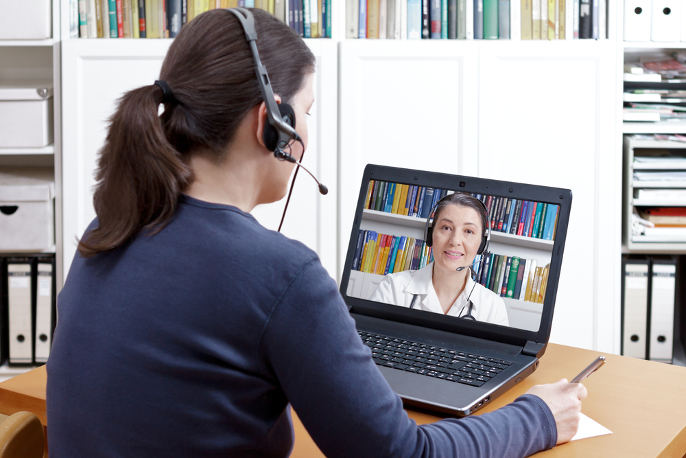 Woman meeting with her doctor virtually while video conferencing on her laptop.